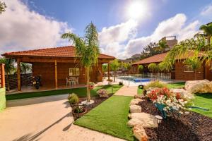 a backyard with a house and a yard with green grass at צמרת הצימרים - מתחם צימרים מקסים עם בריכה במתחם וג'קוזי פרטי - Vacation complex with heated pool and private jacuzzi in Dāliyat el Karmil