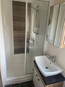 a bathroom with a white sink and a shower at Luxury 6 Berth Caravan, Marton Mere in Blackpool