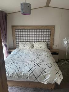 a bedroom with a large bed with a wooden headboard at Luxury 6 Berth Caravan, Marton Mere in Blackpool