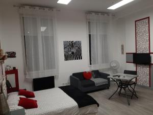 a living room with a bed and a couch at Appartement T1 Hyper Centre place de la Victoire in Bordeaux