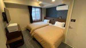 een hotelkamer met 2 bedden en een raam bij HOTEL LiVEMAX Kamata Ekimae in Tokyo