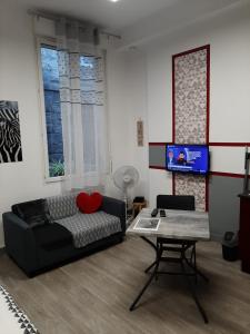 a living room with a couch and a table at Appartement T1 Hyper Centre place de la Victoire in Bordeaux