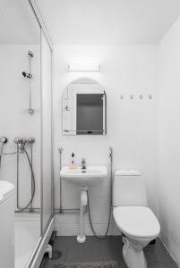 a white bathroom with a toilet and a sink at Fresh 2BR-apartment with FREE parking in Pori