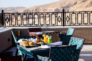 una mesa con comida y bebida en el balcón en Petra Moon Luxury Hotel, en Wadi Musa