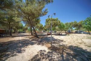 a park with trees and a street light at Camping Vrata Krke in Lozovac