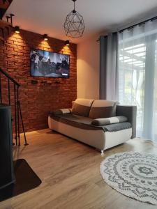 a living room with a bed and a brick wall at Leśny Zaułek in Muszyna