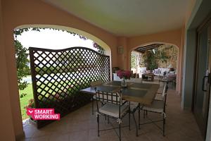 a balcony with a table and chairs on a patio at Sa Pedra House by Wonderful Italy in Porto Rotondo