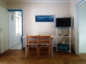 a room with a table and a chair and a television at Camping La Loire Fleurie in Le Perrier