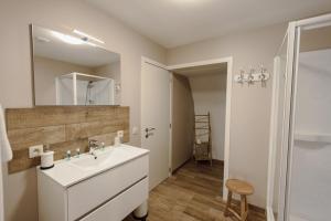 a white bathroom with a sink and a mirror at Le Relais De La Motte in Soignies