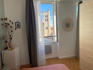 a bedroom with a window with a clock tower at Jungle et Nature in Gannat