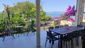 a table and chairs on a balcony with a view of the water at Pansion Marta in Bibinje
