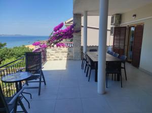 a table and chairs on a balcony with a view of the ocean at Pansion Marta in Bibinje