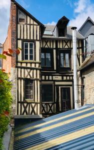 a black and white house with a building at L'Entre-Deux Honfleur in Honfleur