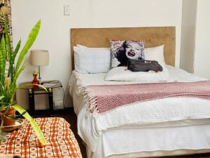 a bedroom with a bed with a clown pillow at Su Casa Chase Valley VA in Pietermaritzburg