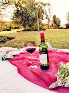 a bottle of wine sitting next to a glass of wine at Hadassa Guest House in Burgersfort