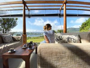 a woman sitting on a couch in front of a window at W15 Lake Gregory in Nuwara Eliya