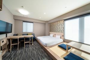 東京にあるKOKO HOTEL Residence 浅草かっぱ橋のベッドとダイニングルームが備わるホテルルームです。