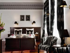 a hotel room with a bed and a chair at Hotel Holland House Old Town in Gdańsk