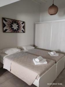 a bedroom with two beds with towels on them at Smyrnis Apartments in Ermoupoli