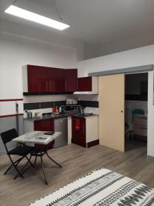 a kitchen with red cabinets and a table in a room at Appartement T1 Hyper Centre place de la Victoire in Bordeaux