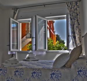 モンテロッソ・アル・マーレにあるDIAMANTE BLU Cod.Citra 011019-LT-0241の窓2つ、景色を望むベッド1台が備わる客室です。