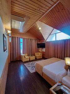 a bedroom with a bed and a couch and a tv at The Whitestone Resorts in Manāli