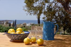 PosidhoníaにあるGood Life Greece Eco Villasの青いマグカップをかけたテーブルの上にレモンを盛り付けた器
