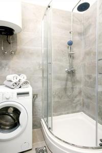 ein Bad mit einer Dusche und einer Waschmaschine in der Unterkunft Apartment Kristina in Trogir