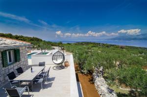 un patio con tavolo, sedie e vista sull'oceano di Holiday Home Bliss a Splitska