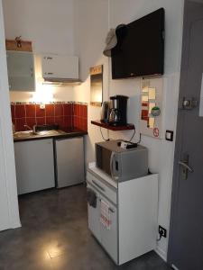 a kitchen with a microwave and a tv on the wall at T1bis duplex Hyper centre historique de BX in Bordeaux