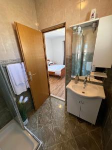 een badkamer met een wastafel, een spiegel en een bed bij Apartmani Bakovic in Hvar