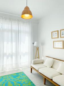 a living room with a white couch and a window at Il fenicottero, Marzamemi in Marzamemi