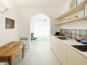 a kitchen with white cabinets and a wooden table at Il fenicottero, Marzamemi in Marzamemi +6 photos