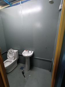 een kleine badkamer met een toilet en een wastafel bij PS Din Kontenastay in Kota Bharu