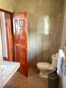 a bathroom with a toilet and a sink at Toba Sunset in Tuktuk Siadong