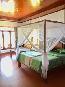 a bedroom with a bed with a canopy at Toba Sunset in Tuktuk Siadong