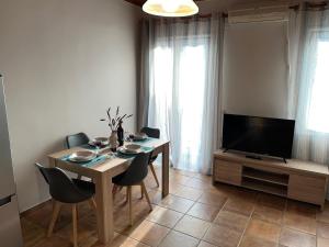 a living room with a table with chairs and a television at The comfort in Raches