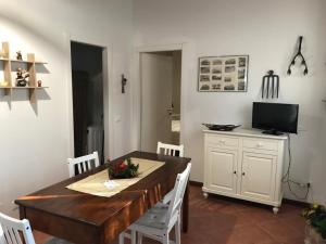 een eetkamer met een houten tafel en een televisie bij L'Ulivo in Villa Greco in Tindari