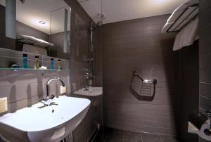 y baño con lavabo y espejo. en Hotel Mansion, en Ámsterdam