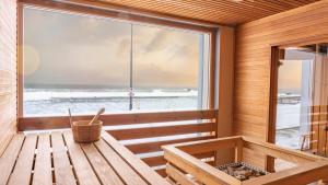 a wooden sauna with a large window and a bench at Viinistu Art Hotel in Viinistu