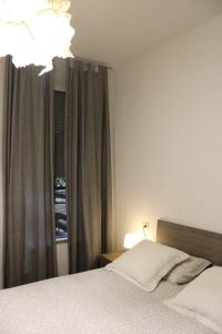 Schlafzimmer mit einem Bett und einem Fenster mit Vorhängen in der Unterkunft Appartamento Sole in centro a Bologna WI-FI Fibra in Bologna