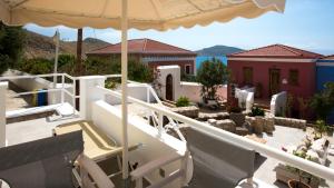 a balcony of a house with an umbrella at Chic & Modern Apartments with swim access in Halki