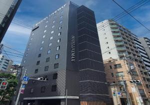 een hoog gebouw met een bord aan de zijkant bij HOTEL LiVEMAX Kamata Ekimae in Tokyo