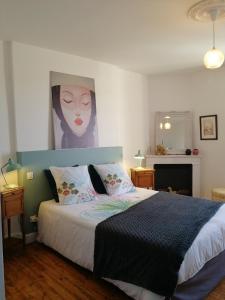 1 dormitorio con 1 cama con una pintura en la pared en le gîte du fou logement 8 pers 13mn puy du fou en Saint-Amand-sur-Sèvre