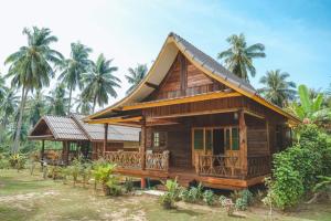 a small wooden house with a gambrel roof at Kohjum Freedom Resort in Ko Jum