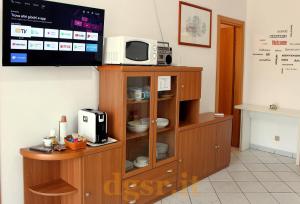 una TV in cima a un mobile in legno con forno a microonde di Villa Grazia a Ostuni