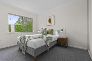 a white bedroom with a bed and a window at Luxury on Lewes in Perth