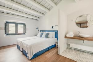 ein weißes und blaues Schlafzimmer mit einem Bett und einem Waschbecken in der Unterkunft Flateli Casa Oliver in Cerviá de Ter