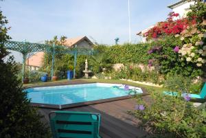a swimming pool in a yard with flowers at Casal Santo Antonio in Sintra