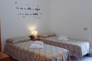 dwa łóżka w pokoju z napisem na ścianie w obiekcie Villa Grazia w mieście Ostuni